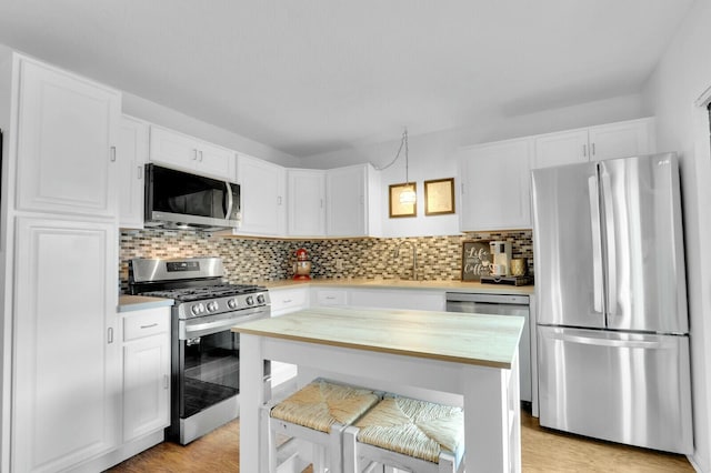 kitchen featuring white cabinets, backsplash, and stainless steel appliances