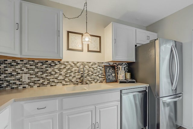 kitchen featuring tasteful backsplash, sink, white cabinets, and appliances with stainless steel finishes