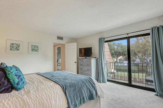 carpeted bedroom with a textured ceiling and access to outside