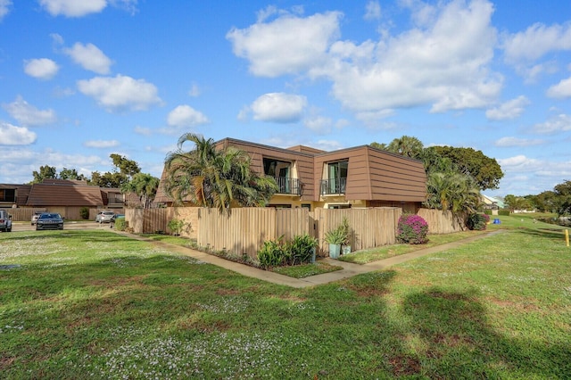 view of property exterior featuring a lawn and a balcony