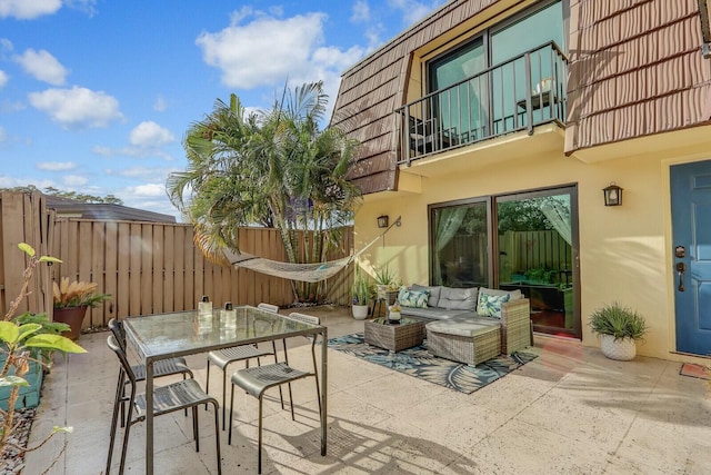 view of patio with outdoor lounge area and a balcony