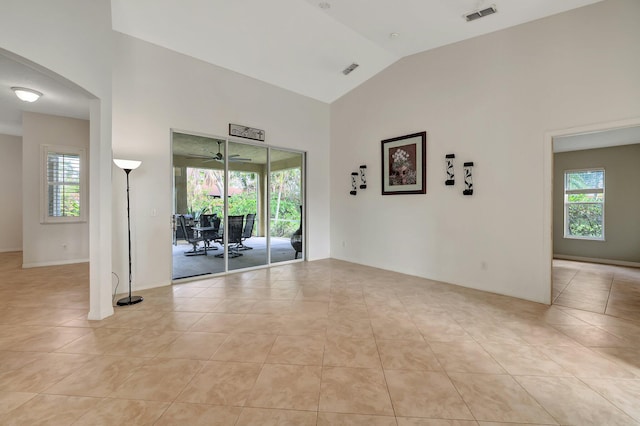 tiled spare room featuring high vaulted ceiling and a wealth of natural light