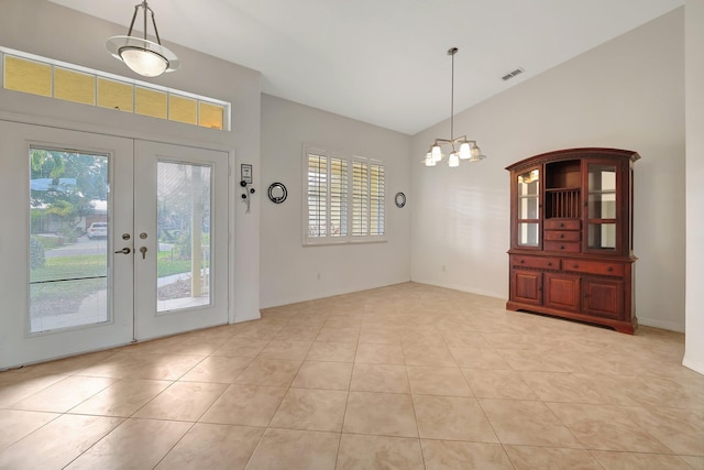 unfurnished dining area with a notable chandelier, light tile patterned floors, a wealth of natural light, and french doors