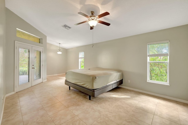 bedroom with ceiling fan, vaulted ceiling, french doors, and multiple windows