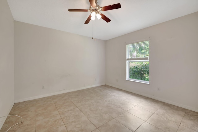 tiled spare room featuring ceiling fan