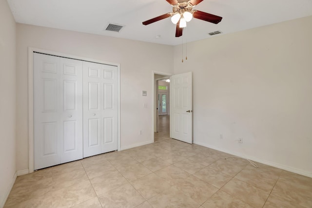 unfurnished bedroom with light tile patterned floors, a closet, and ceiling fan