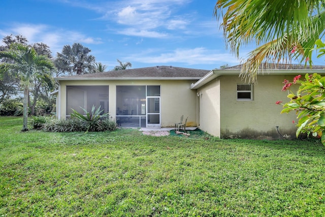 rear view of property featuring a sunroom and a yard