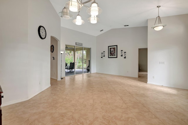 tiled spare room with high vaulted ceiling and a chandelier