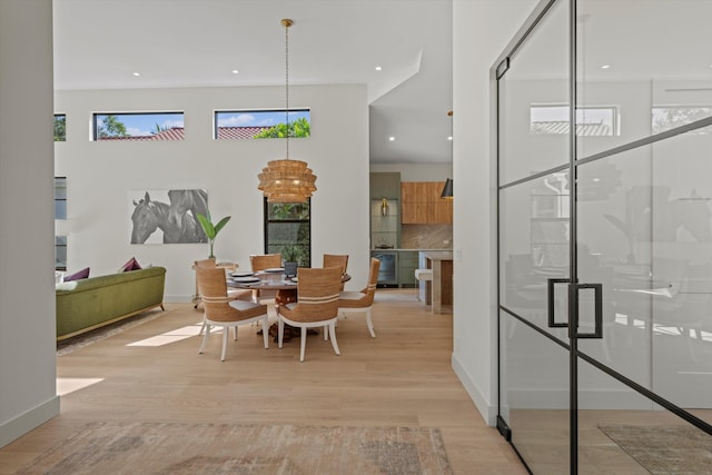 dining room with light hardwood / wood-style floors, a wealth of natural light, and beverage cooler