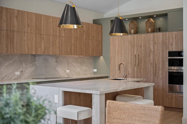 kitchen featuring tasteful backsplash, sink, wood-type flooring, a center island, and hanging light fixtures