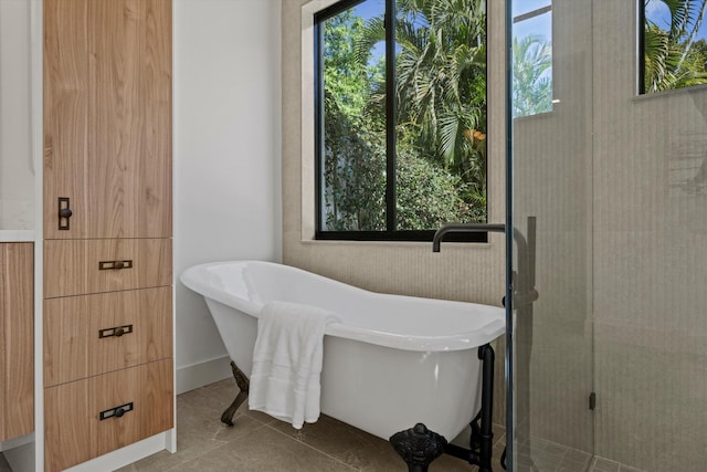 bathroom with a washtub, plenty of natural light, and tile patterned flooring