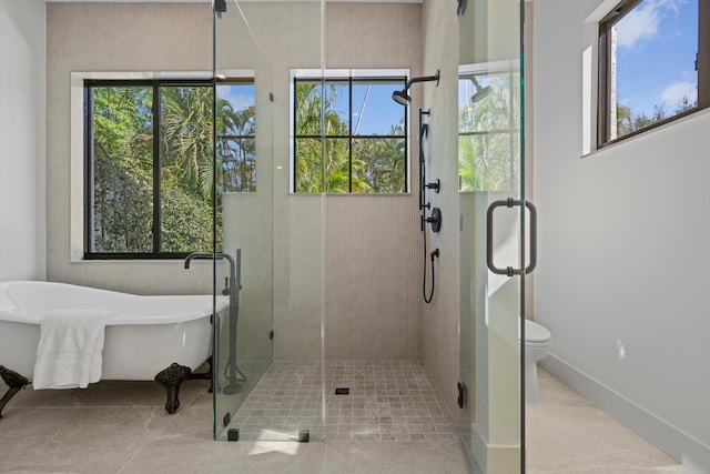 bathroom featuring shower with separate bathtub, toilet, and a healthy amount of sunlight