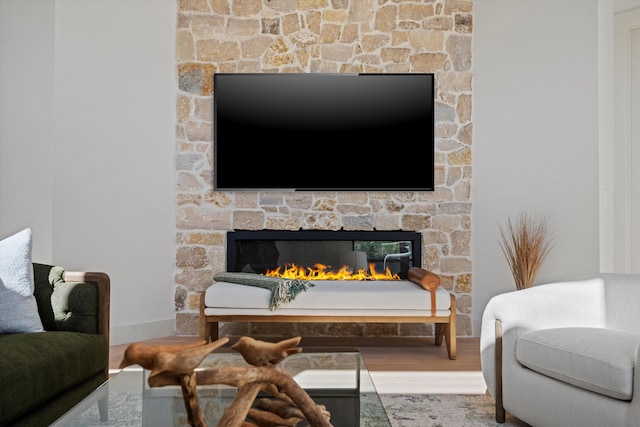 living room featuring a stone fireplace and hardwood / wood-style flooring