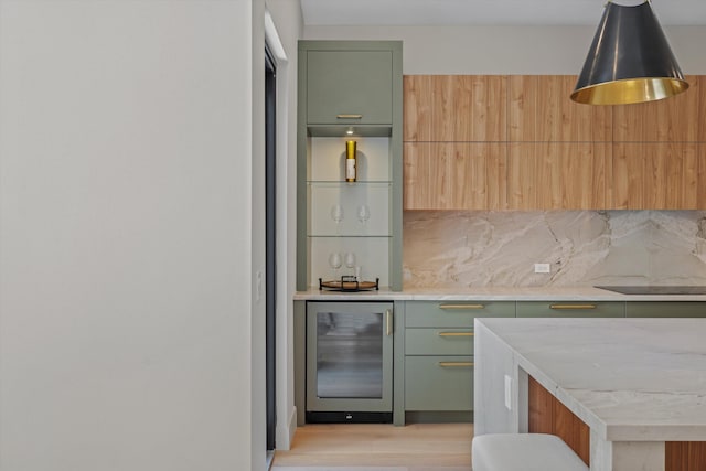 kitchen featuring tasteful backsplash, light hardwood / wood-style flooring, beverage cooler, and green cabinets