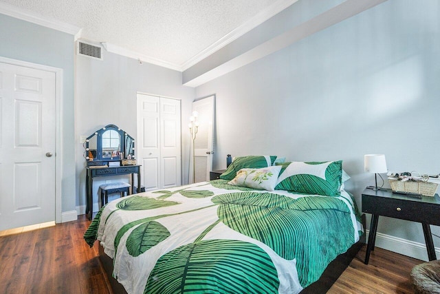 bedroom with crown molding, dark wood-type flooring, a textured ceiling, and a closet