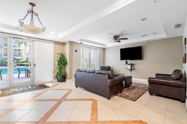 living room featuring a tray ceiling, plenty of natural light, and light tile patterned flooring