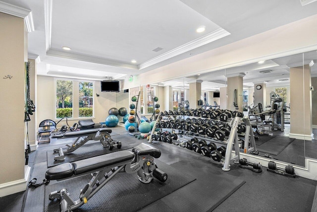 gym with a tray ceiling and crown molding