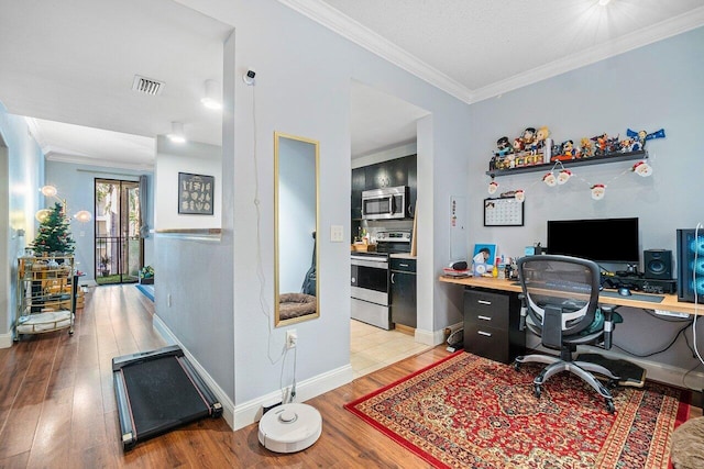 home office with ornamental molding and light hardwood / wood-style flooring