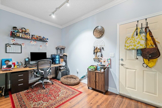 office space featuring a textured ceiling, light wood-type flooring, rail lighting, and crown molding