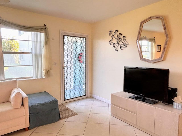 living area with baseboards and light tile patterned floors