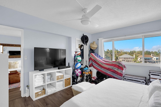 bedroom with ceiling fan, dark hardwood / wood-style floors, and a textured ceiling