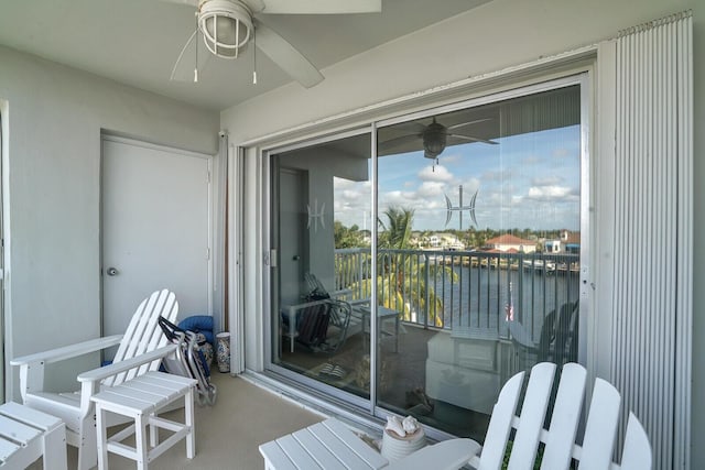 balcony featuring a water view and ceiling fan