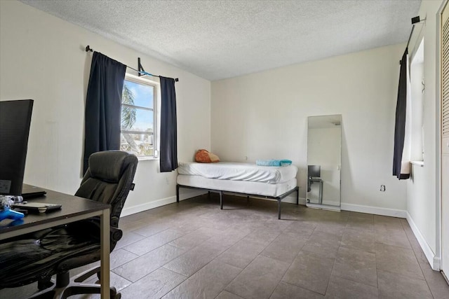 bedroom featuring a textured ceiling and baseboards