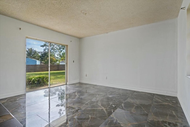 unfurnished room featuring a textured ceiling, marble finish floor, and baseboards