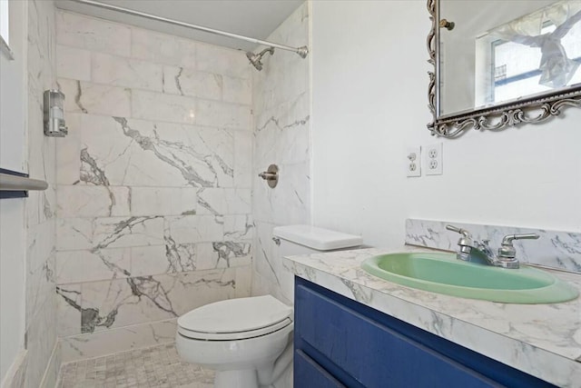 full bath featuring toilet, vanity, and a marble finish shower