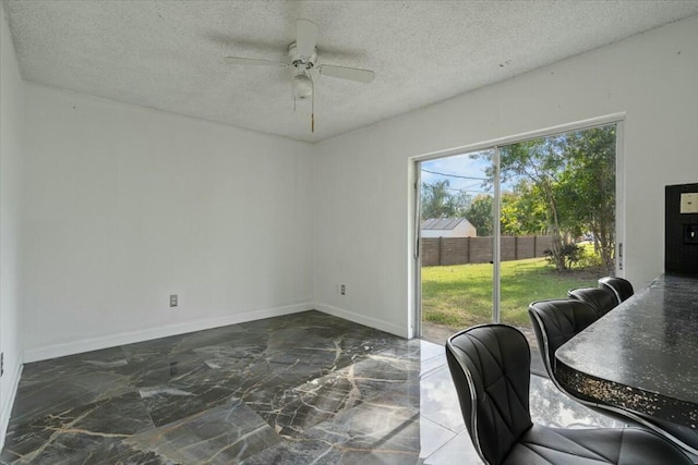 dining area featuring marble finish floor, ceiling fan, baseboards, and a textured ceiling