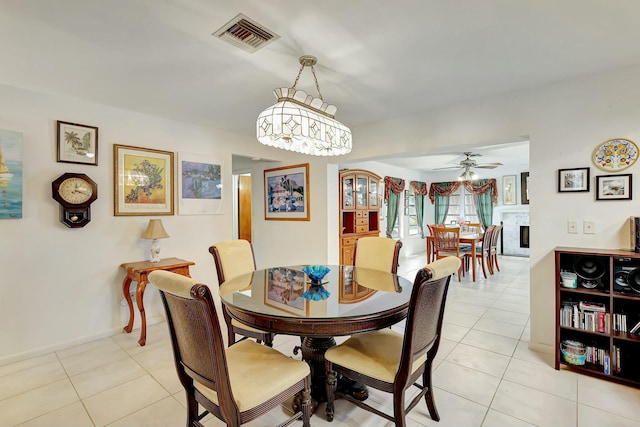 dining room with light tile patterned floors and ceiling fan with notable chandelier