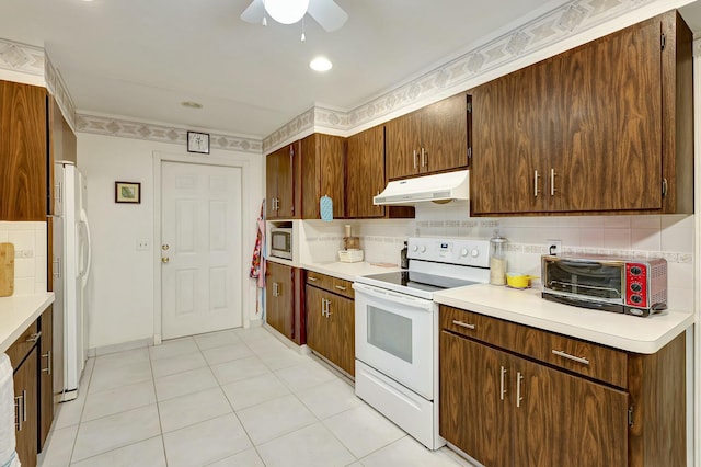 kitchen with decorative backsplash, light tile patterned floors, white appliances, and ceiling fan