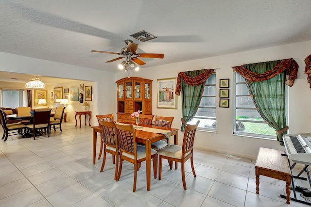 tiled dining space featuring a textured ceiling and ceiling fan