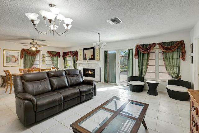 tiled living room featuring a high end fireplace, a textured ceiling, and ceiling fan with notable chandelier