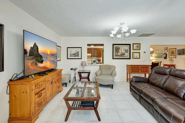 living room featuring a notable chandelier, light tile patterned floors, and a textured ceiling