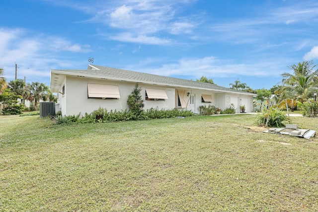 ranch-style home with cooling unit and a front lawn