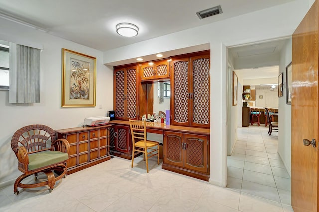 home office with light tile patterned floors and built in desk