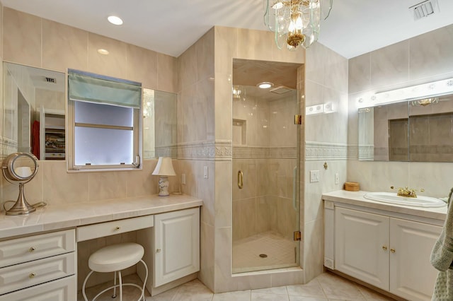 bathroom featuring tile patterned flooring, vanity, a shower with shower door, and tile walls