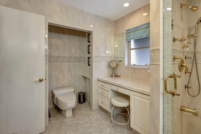 bathroom featuring tile patterned flooring, toilet, tile walls, and walk in shower