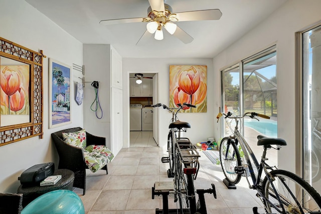 workout room with ceiling fan, light tile patterned flooring, and washer and dryer