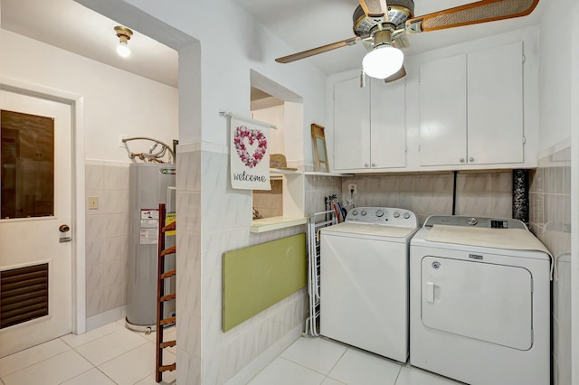 laundry room featuring cabinets, separate washer and dryer, water heater, light tile patterned floors, and tile walls