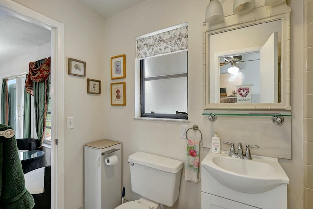 bathroom featuring plenty of natural light, ceiling fan, toilet, and vanity