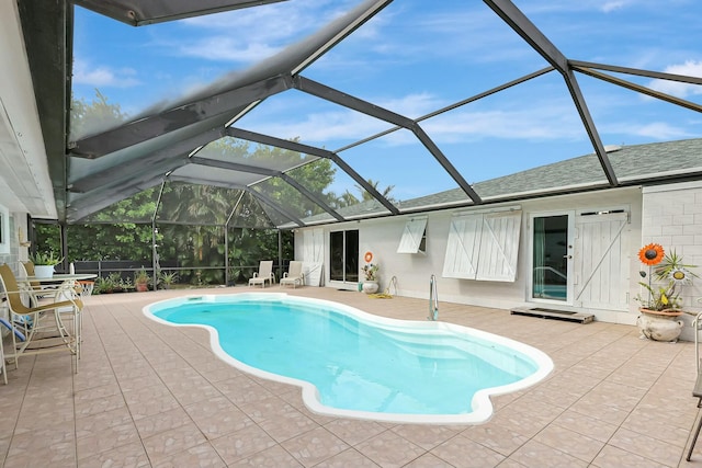 view of swimming pool with glass enclosure and a patio