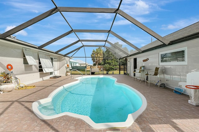 view of swimming pool featuring a lanai and a patio