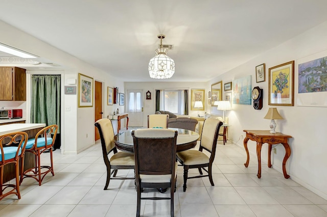 dining room with a chandelier and light tile patterned floors