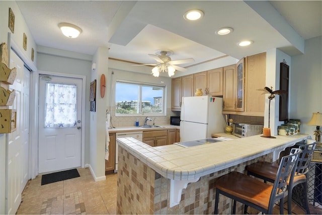 kitchen featuring backsplash, kitchen peninsula, a breakfast bar, and white appliances