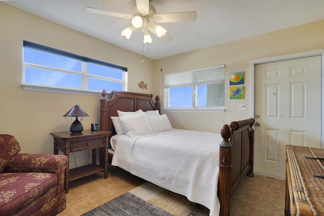 tiled bedroom with a textured ceiling and ceiling fan