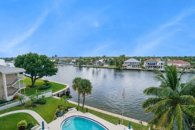 view of pool featuring a water view and a lawn