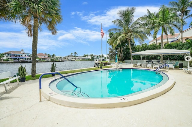 view of pool featuring a patio and a water view