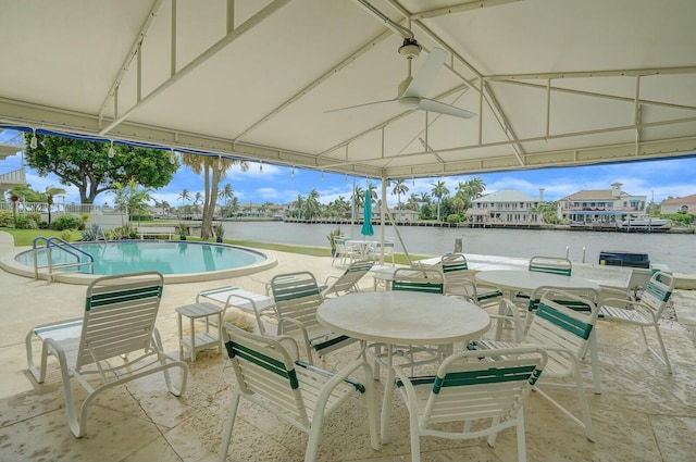 view of patio / terrace featuring a gazebo, ceiling fan, a water view, and a community pool